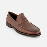The Fischer Penny Leather Loafer by TO BOOT is a single brown leather slip-on shoe, crafted in Italy with a low heel and a traditional penny slot on the vamp, shown against a plain white background.