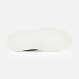 The image shows the bottom view of a white shoe sole against a plain white background, highlighting the craftsmanship of the TO BOOT James Slip On Sneaker.