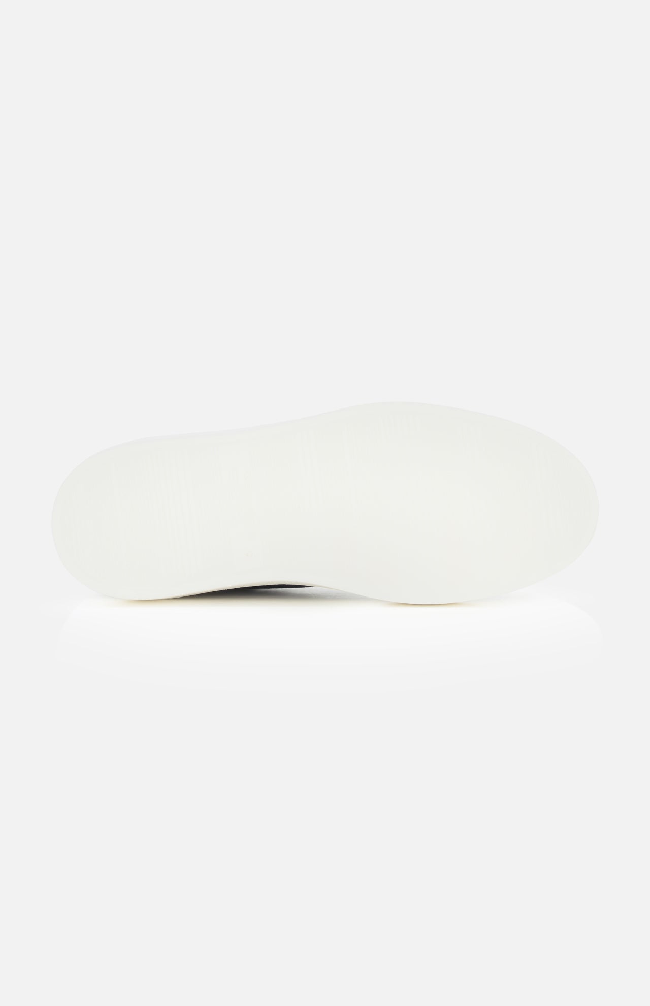 The image shows the bottom view of a white shoe sole against a plain white background, highlighting the craftsmanship of the TO BOOT James Slip On Sneaker.