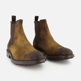 The Largo Suede Chelsea Boot by TO BOOT is a classic men’s footwear choice, crafted in brown suede with elastic side panels and durable black rubber soles, all showcased on a white background.