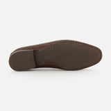 The image displays the bottom view of the TO BOOT Merritt Deer Leather Penny Loafer, featuring a textured rubber sole and prominent stitching around the edge that highlights the craftsmanship characteristic of classic loafers.