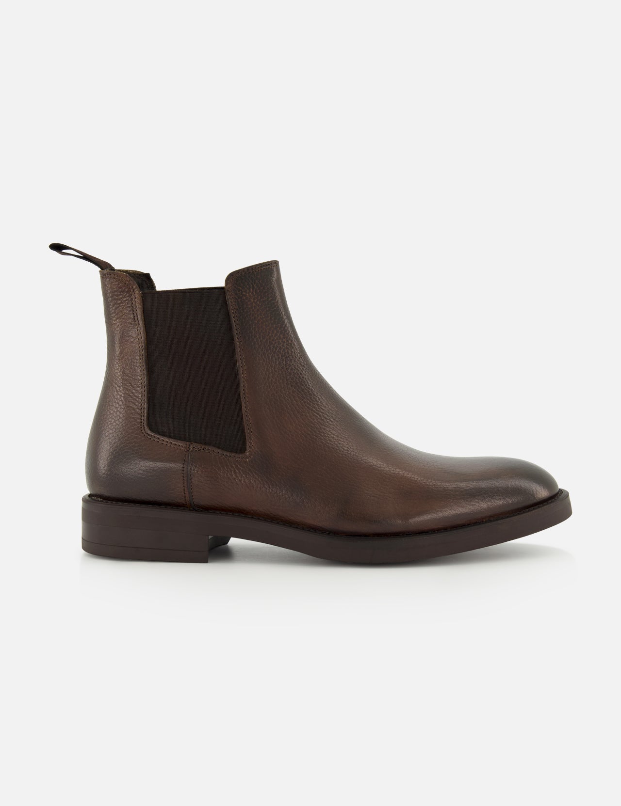 The Peabody Chelsea Boot by TO BOOT is a men’s brown grained leather boot with a black elastic side panel, back pull tab, and low heel, shown in profile on a white background.