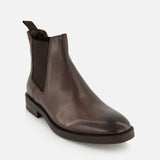 The Peabody Chelsea Boot by TO BOOT is a men’s fall boot in grained leather with elastic side panels and a pull tab at the back, shown on a white background.