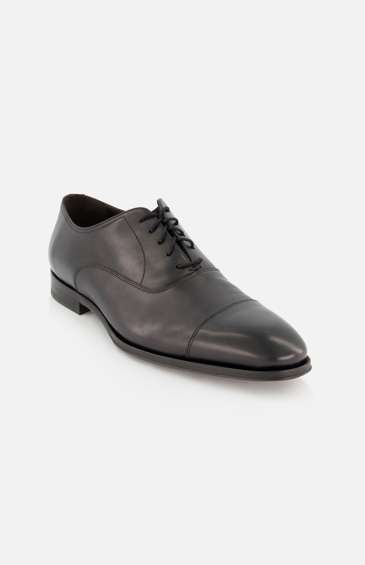 The TO BOOT Nico Leather Oxford is a black leather dress shoe with laces, low heel, and cap toe, hand burnished for a refined finish and shown on a white background.