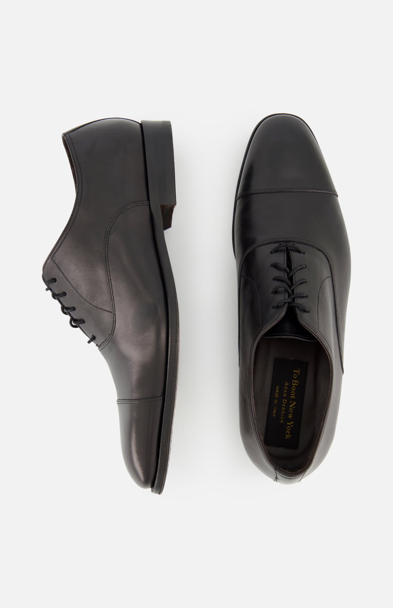 The TO BOOT Nico Leather Oxford features black hand-burnished leather, shown from the side and above with laces and a sleek, polished design inspired by fine Italian style.