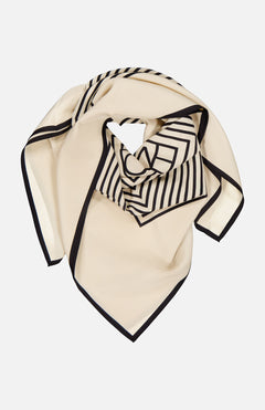 The TOTEME Centered Monogram Silk Scarf features cream silk with a black border and geometric stripes, styled in a loose fold—a chic accessory to elevate any woman's fashion look.