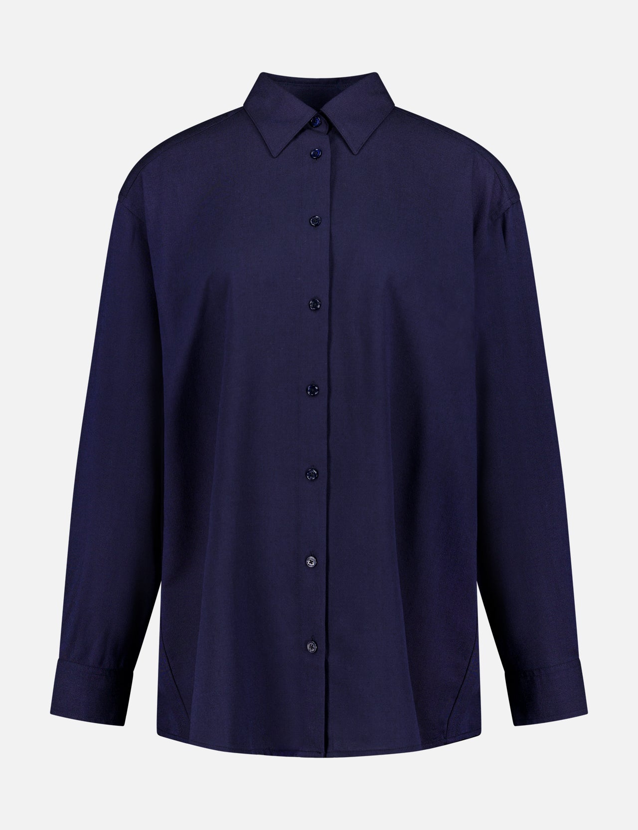 The Classic Fluid Oversized Shirt by TOTEME is a navy longline shirt with a collar and long sleeves, made from a soft viscose-wool blend. Shown buttoned up against a white background.