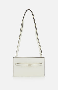 The TOTEME Belted Naplack Crossbody Bag is a minimalist white leather handbag with a long strap, subtle black trim, and a slim horizontal accent on the front. Made in Italy. Displayed against a plain white background.