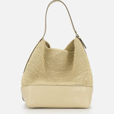 The TOTEME Belted Woven Leather Tote Bag features a beige woven leather design, a curved top handle, and a smooth solid beige leather base, shown against a plain white background.