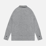 A TOTEME Cashmere Long Sleeve Cardigan in grey is laid flat on a white background with the back side facing up. This featherlight sweater features a ribbed hem and cuffs, along with distinctive button details on the sleeves.