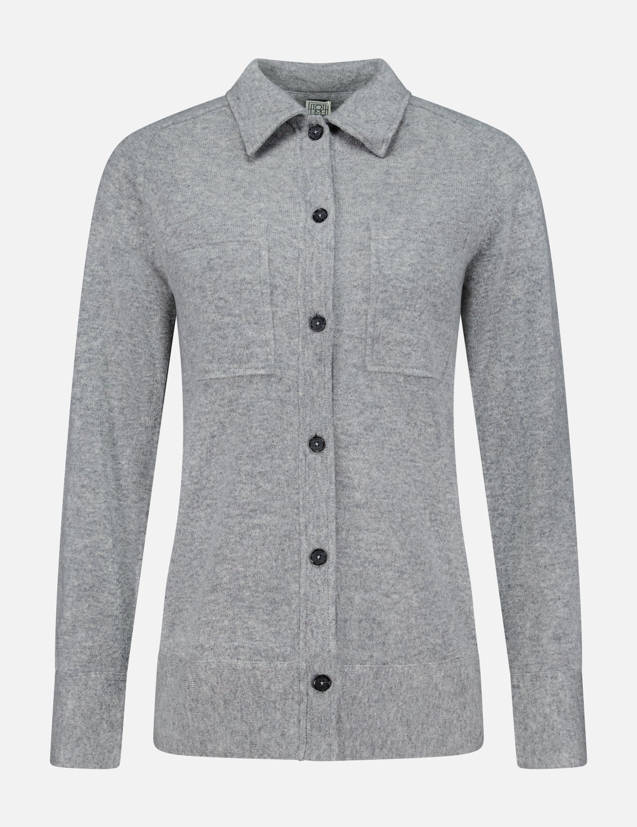 The TOTEME Cashmere Long Sleeve Cardigan is a light gray, featherlight cashmere button-up with long sleeves, a collar, and two chest pockets. Featuring a classic button-front closure, it is shown against a plain white background.