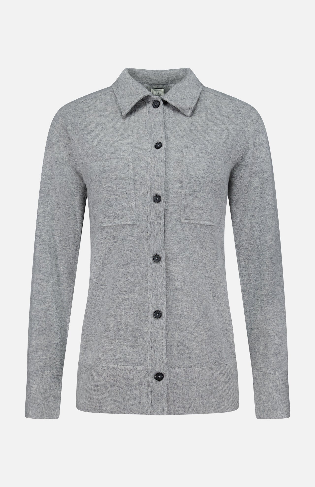 The TOTEME Cashmere Long Sleeve Cardigan is a light gray, featherlight cashmere button-up with long sleeves, a collar, and two chest pockets. Featuring a classic button-front closure, it is shown against a plain white background.