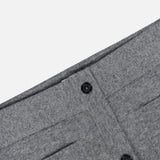 Detailed close-up of the TOTEME Buttoned Cashmere Skirt in grey, showcasing its slim-fit waistband with two black buttons, vertical seams, and subtle patch pockets for added detail.