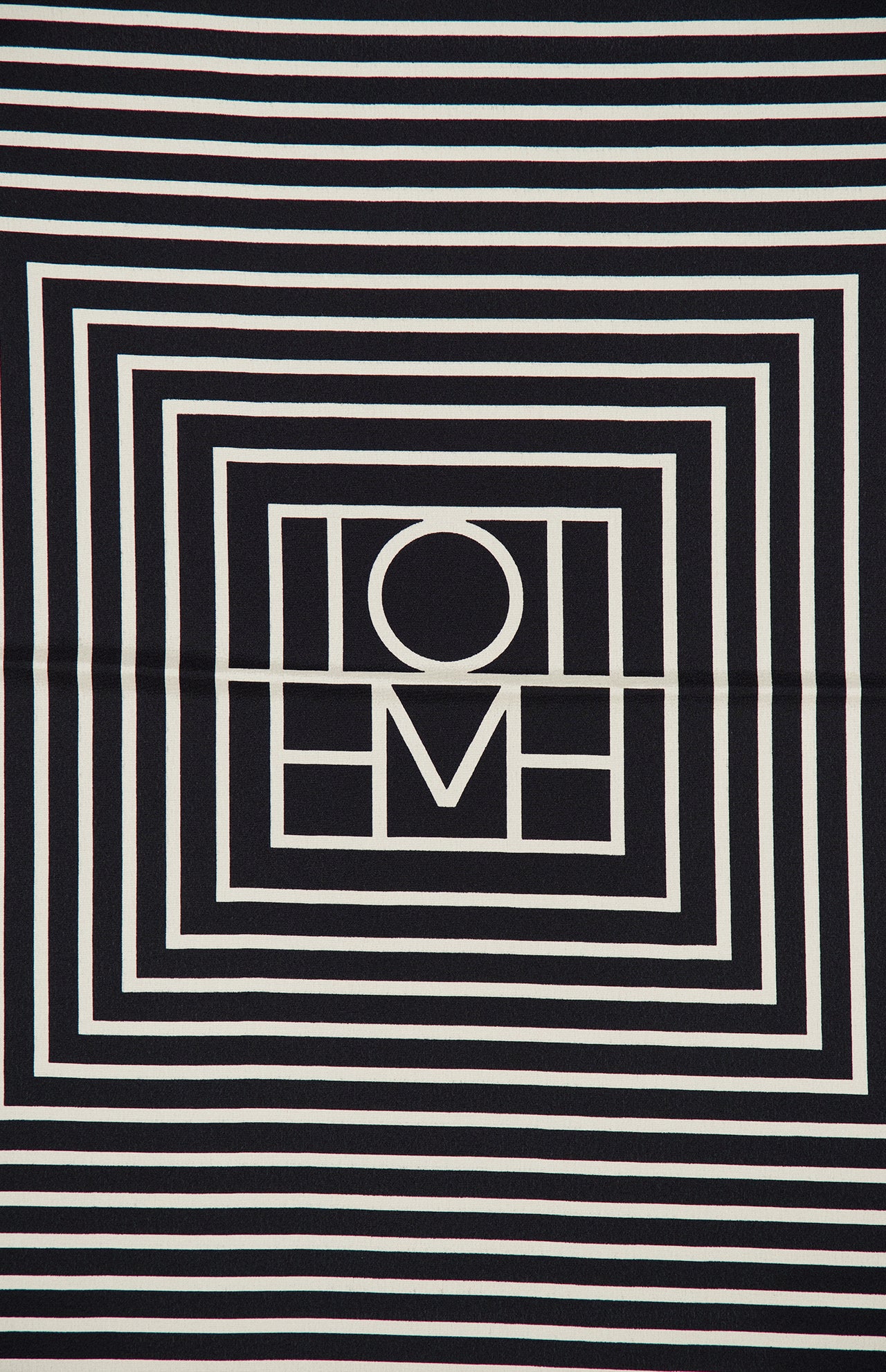 Featuring a striking black and white geometric square pattern, the Centered Monogram Silk Scarf by TOTEME showcases concentric lines and shapes forming a bold central design. This elegant, symmetrical accessory makes a sophisticated statement and would look exquisite worn as a monogram silk scarf.
