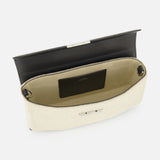 The TOTEME Clip Canvas Shoulder Bag, crafted in beige canvas with leather accents and a black interior flap, reveals a spacious compartment and a small pocket with a black label, displayed against a white background.