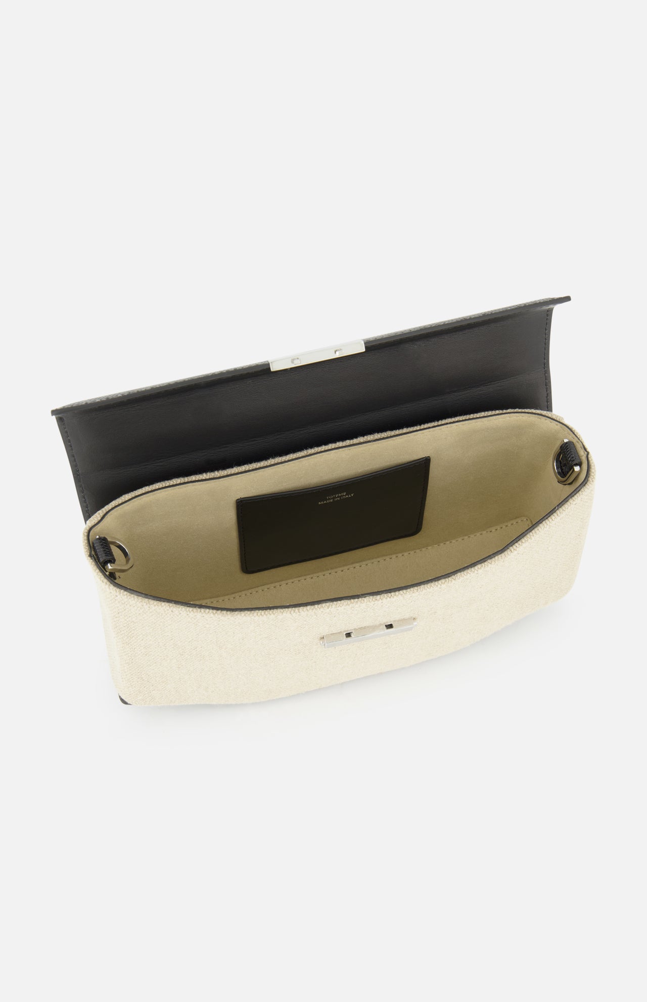The TOTEME Clip Canvas Shoulder Bag, crafted in beige canvas with leather accents and a black interior flap, reveals a spacious compartment and a small pocket with a black label, displayed against a white background.