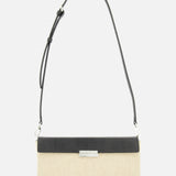 The TOTEME Clip Canvas Shoulder Bag is a rectangular beige and black accessory in canvas and leather, designed with a long adjustable strap, silver front clasp, and minimalist modern style, shown on a plain white background.