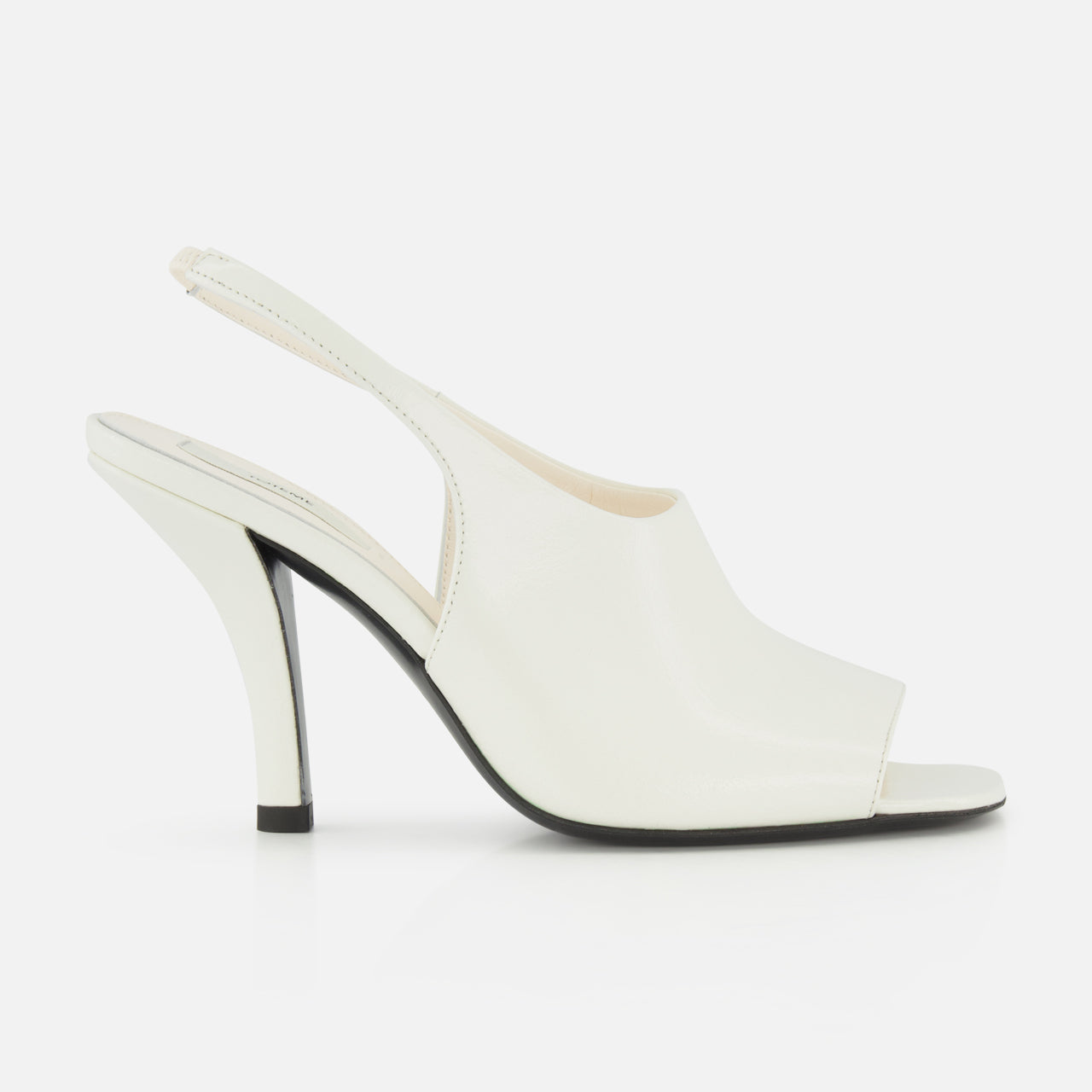 The TOTEME Contour Naplack Slingback Heel is a white leather peep-toe shoe with a curved high heel and black sole, shown against a white background.