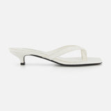 The TOTEME Croco Embossed Heeled Flip Flops feature white croco-embossed leather, a thong strap, and a low kitten heel, shown in side profile against a plain white background.