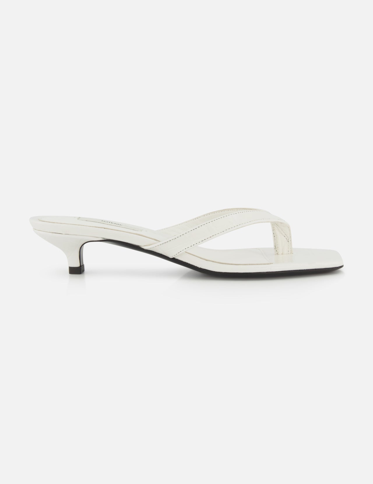 The TOTEME Croco Embossed Heeled Flip Flops feature white croco-embossed leather, a thong strap, and a low kitten heel, shown in side profile against a plain white background.