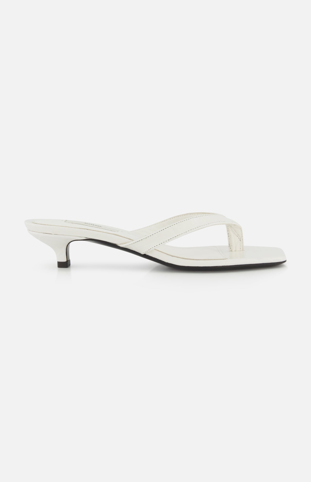 The TOTEME Croco Embossed Heeled Flip Flops feature white croco-embossed leather, a thong strap, and a low kitten heel, shown in side profile against a plain white background.