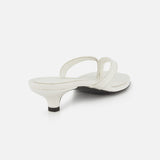The Croco Embossed Heeled Flip Flops by TOTEME are white sandals in croco-embossed leather with a low kitten heel and two thin straps, shown from a rear angled view on a plain white background.