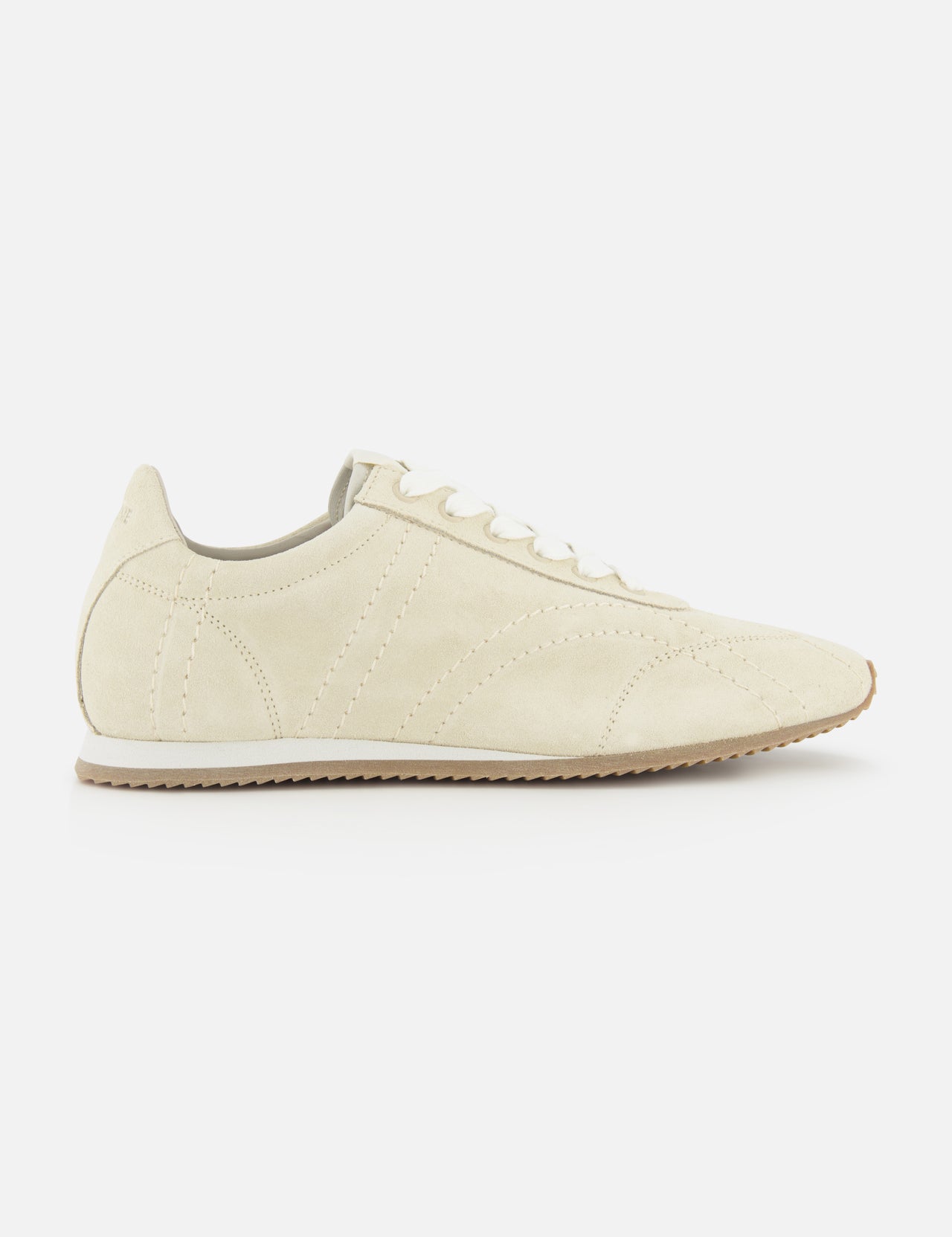 A side view of TOTEME's Flex Suede Low Profile Sneakers in beige, featuring white laces and a light brown rubber sole, photographed on a plain white background—expertly crafted in Italy for timeless appeal.