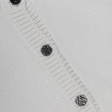 Close-up of the TOTEME Hammered Button Cotton Cardigan in white, featuring four hammered silver buttons and ribbed edges. The button-front closure lends classic appeal, with a portion of the label visible at the top left corner.