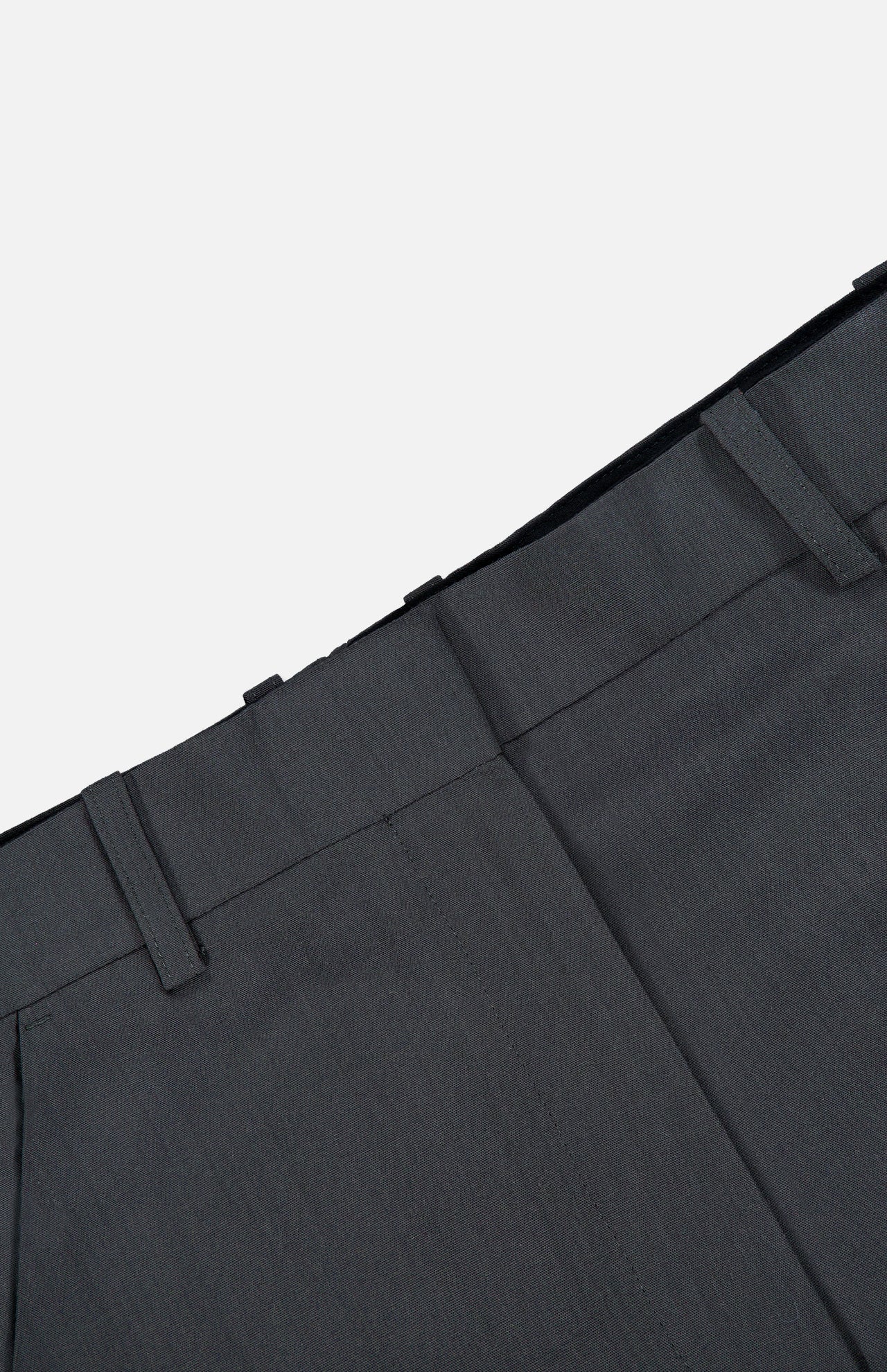 Close-up of the waistband and upper section of TOTEME’s High-Waisted Trouser Pants in dark grey, featuring belt loops and detailed stitching against a plain white background. These office pants offer a high-rise fit for a polished, professional appearance.