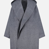 The TOTEME Wool Hoodie Coat is a grey coat crafted from wool, designed with an oversized hood and wide lapels. Featuring an open front, loose relaxed fit, and long sleeves, it is displayed against a plain white background.
