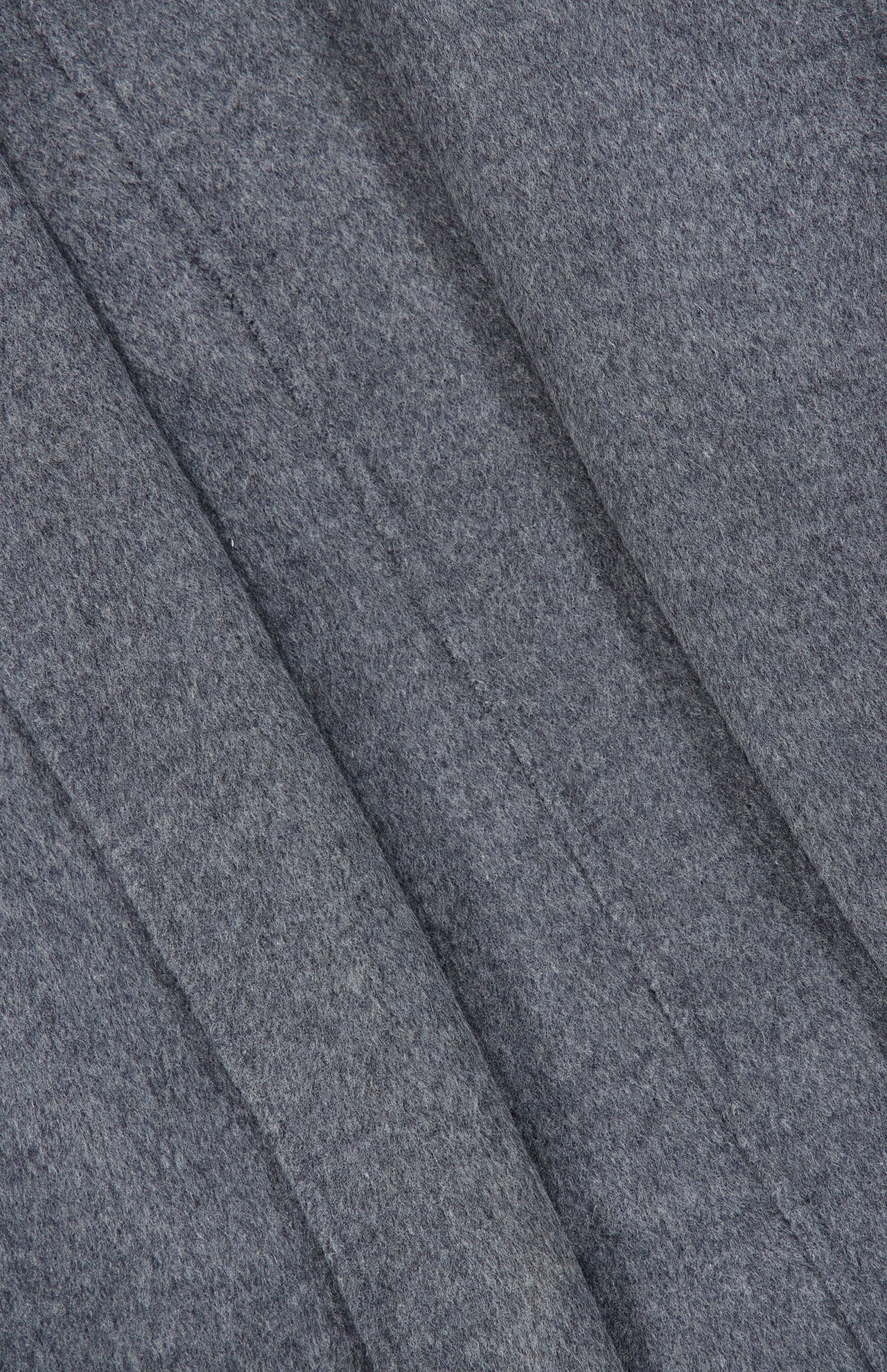Close-up of the gray felt fabric from TOTEME’s Wool Hoodie Coat, featuring visible diagonal seams that highlight the texture and detailed stitching of the material.