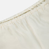 Close-up of TOTEME's Monogram Silk PJ Shorts, featuring an elastic waistband, subtle stitched patterns, and an embroidered monogram for a refined finish.