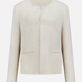 The TOTEME Open-Front Bouclé Blazer features an off-white hue, oversized fit, collarless design, long sleeves, textured bouclé fabric, straight cut, and two front slit pockets. Shown against a plain white background.