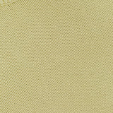 Close-up of the Oversized Crewneck Knit Sweater by TOTEME in butter yellow, showcasing textured stitching and a glimpse of the collar with a white tag.