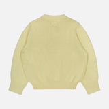 An Oversized Crewneck Knit Sweater by TOTEME in butter yellow is laid flat with the back side facing up, showcasing long sleeves and ribbed detailing on the cuffs, waistband, and neckline against a plain white background.