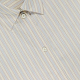 The TOTEME Oversized Pastel Striped Shirt features thin vertical stripes in light blue and brown on beige, a classic collar, and white front buttons for a timeless yet relaxed style.