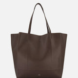 The TOTEME Roam Oversized Leather Tote Bag is shown against a white background. This large, dark brown bag has two handles and a minimalist design with no visible embellishments.