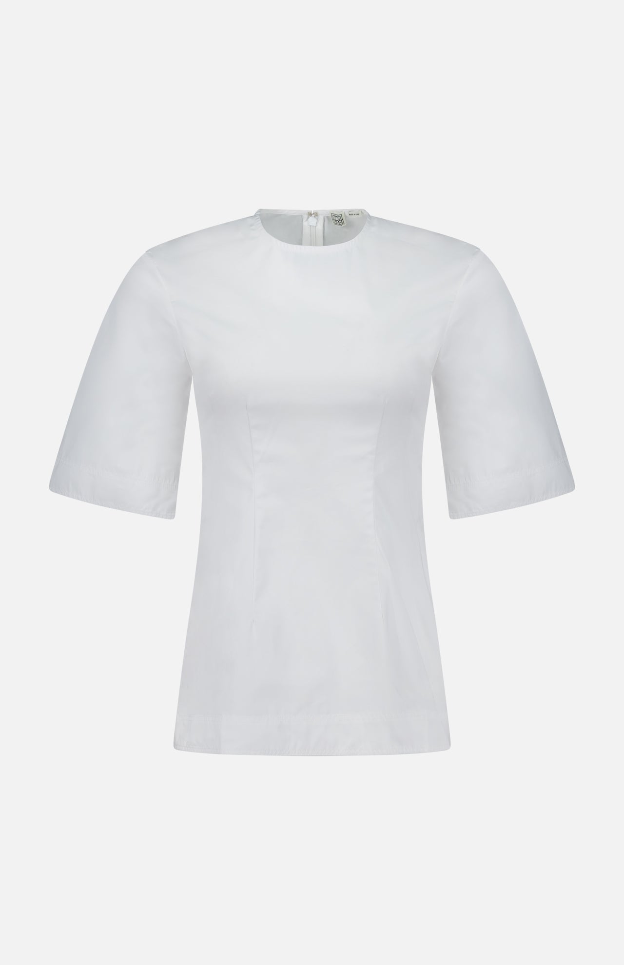 The TOTEME Sculptural Cotton Top is a designer women’s blouse in plain white with short sleeves, a round neckline, and a back zipper. Showcasing clean lines and timeless appeal, it is displayed against a white background.
