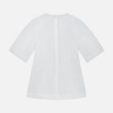 Back view of the TOTEME Sculptural Cotton Top in plain white, showcasing short sleeves and a central zipper. This designer blouse features a loose, subtly flared silhouette with a minimalist design, presented against a white background.
