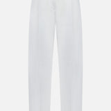 The Single Pleat Cotton Trouser Pants by TOTEME feature a high waist, front pleats, and side pockets, finished with a single black button closure at the waistband. Crafted from cotton with a modern tailored fit, these white trousers are showcased against a plain white background.