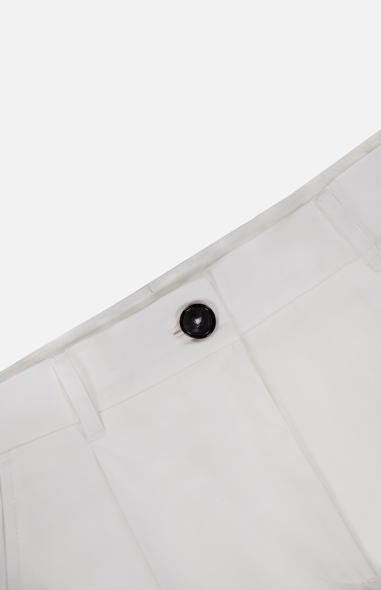 Close-up of the waistband and upper section of TOTEME’s Single Pleat Cotton Trouser Pants in white, showcasing a prominent dark button and belt loops against a plain background.
