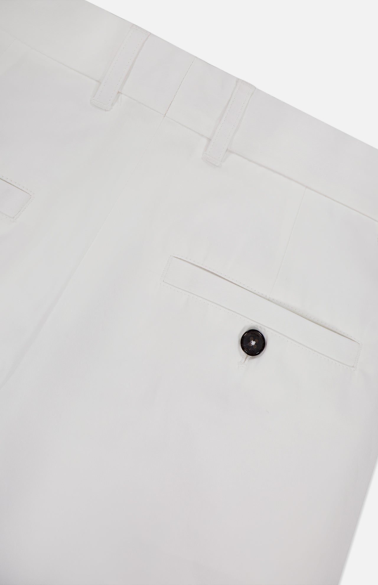Close-up of the back of TOTEME's Single Pleat Cotton Trouser Pants, featuring belt loops, a single back pocket with a black button, and clean stitching detail.
