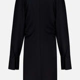 Back view of the TOTEME Slouch Jersey Shirt Dress, a long-sleeved, knee-length black piece with a straight cut, buttoned cuffs, and a simple collar, shown against a plain white background.