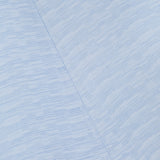 Close-up of the Slouch Waist Dress by TOTEME shows pale blue fabric with fine horizontal textured lines, a diagonal seam, and subtle blue variations—highlighting the elegant style and curved panel design.