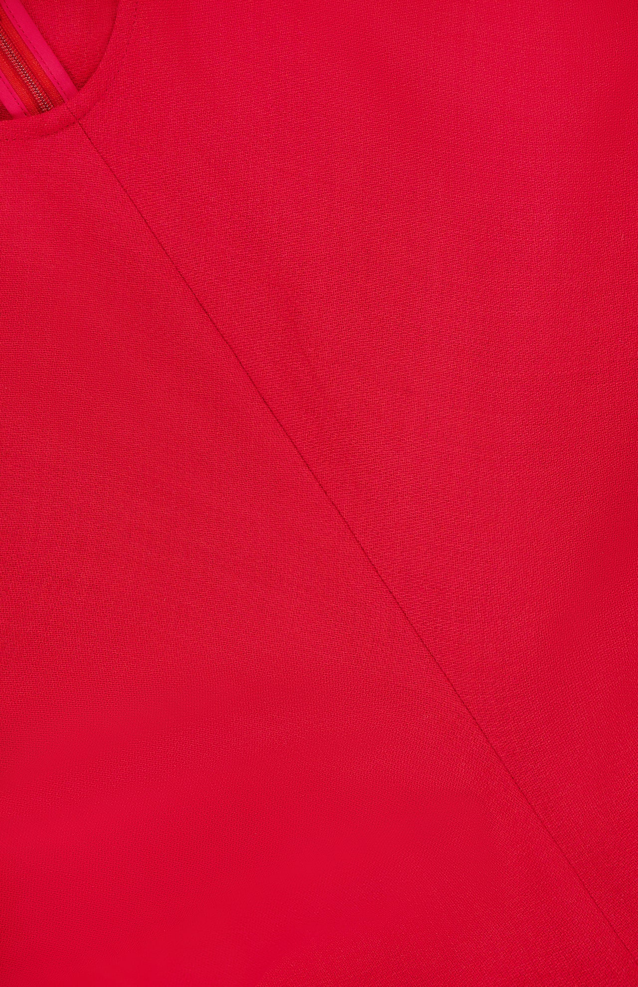 Close-up of vibrant red Slouch Waist Wool Dress by TOTEME, highlighting visible seams and stitching that form diagonal lines and a geometric pattern across the textured fabric.