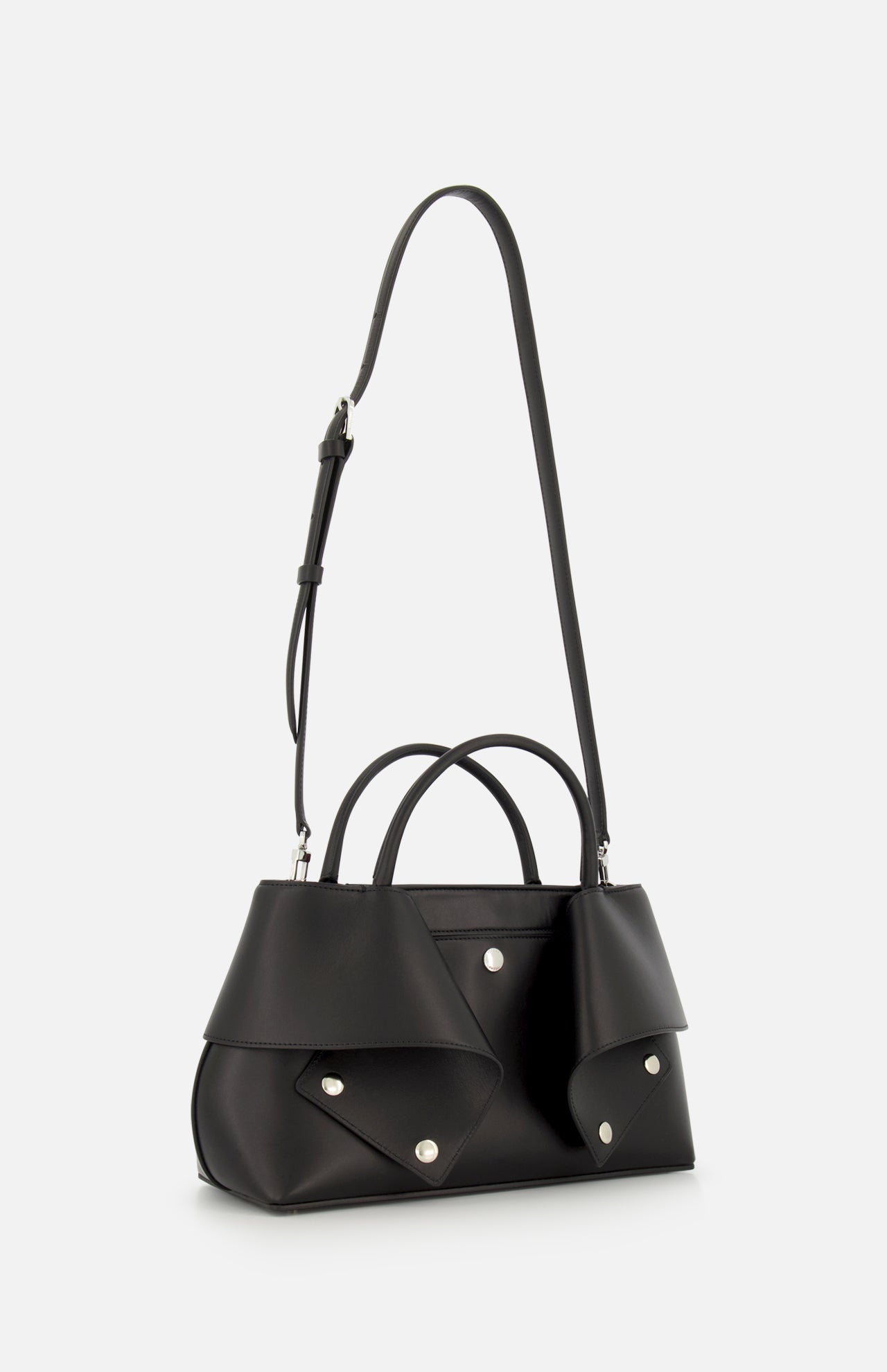 Introducing the TOTEME Small Mercer Leather Tote Bag in black, crafted from premium leather and adorned with silver studs. This designer tote features distinctive geometric flap accents on the sides, dual handles, and an adjustable shoulder strap. Expertly made in Italy, it is showcased against a plain white background.