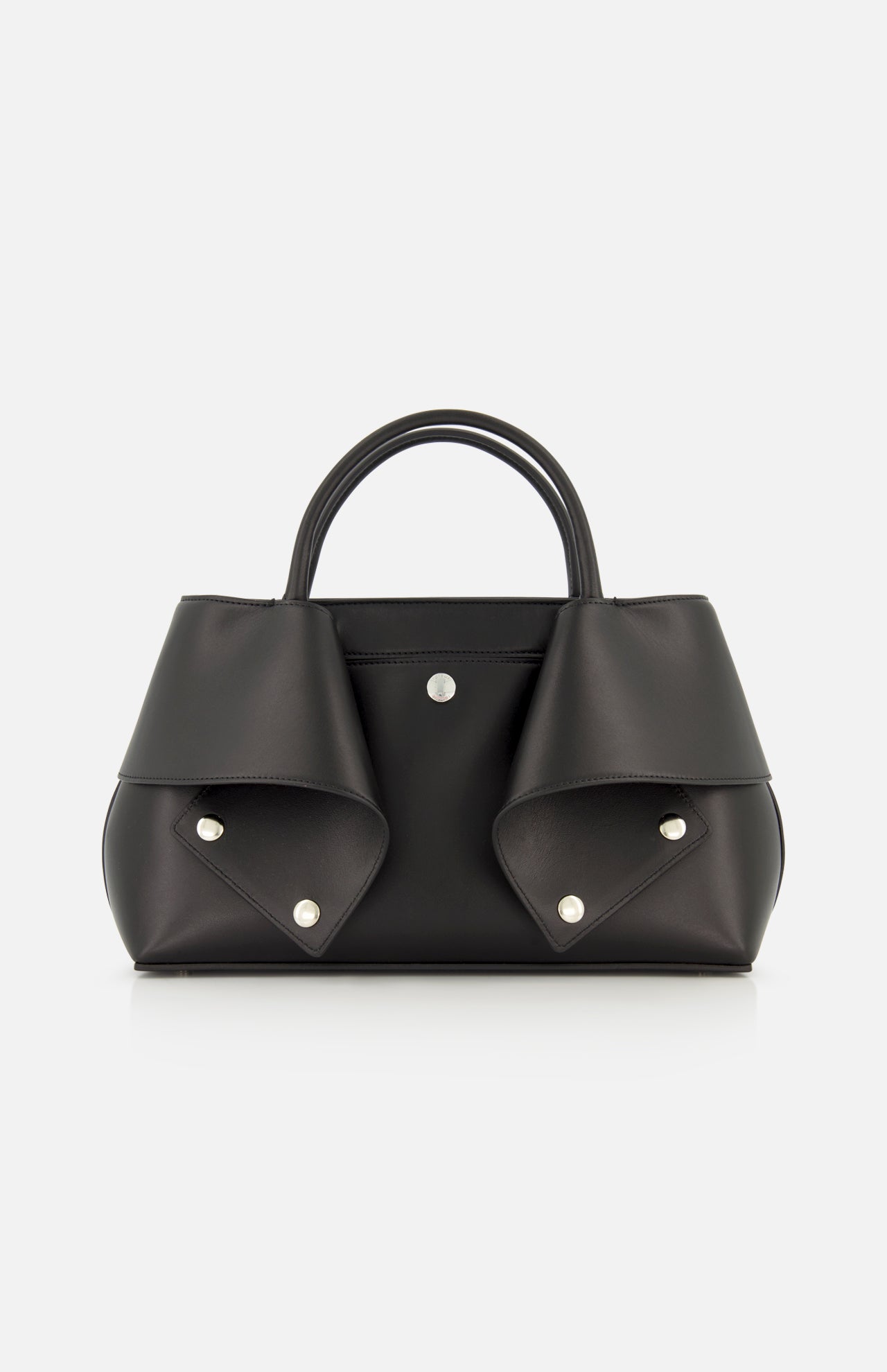 The TOTEME Small Mercer Leather Tote Bag features black leather with two short handles, silver button details, and folded flap accents on each side. Expertly crafted in Italy, this sophisticated designer tote is displayed against a plain white background.