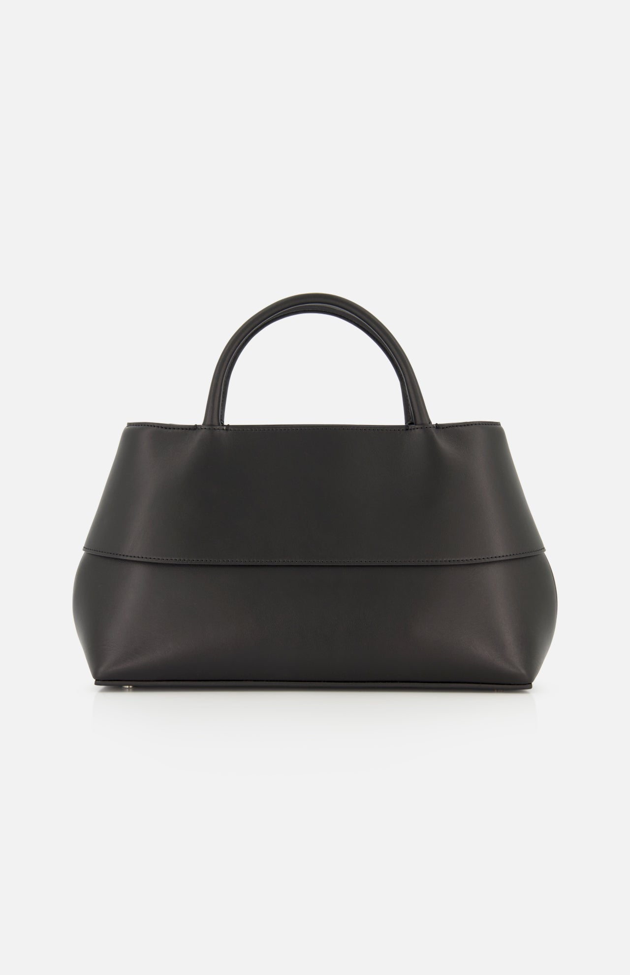 A Small Mercer Leather Tote Bag by TOTEME sits on a white background. Crafted in Italy, this black tote features two short handles, a minimalist design, and a smooth, matte finish.