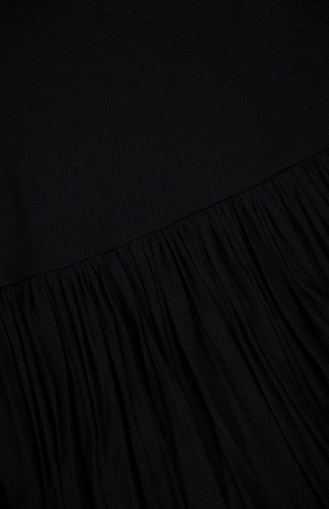 A close-up of the TOTEME Soft Gathered Dress shows sculptural gathering along the lower half contrasted by a smooth upper section—an elegant choice for occasions, featuring a flattering fitted waist.