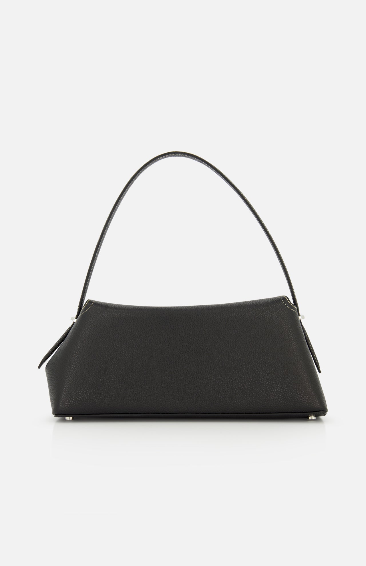 The TOTEME T-Lock Grained Leather Shoulder Bag features a sculptural, rectangular silhouette in black pebble-grained leather with a single curved handle, minimal silver hardware, and is shown against a white background.